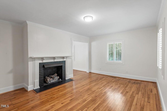 unfurnished living room featuring light wood-style floors, baseboards, a fireplace, and crown molding