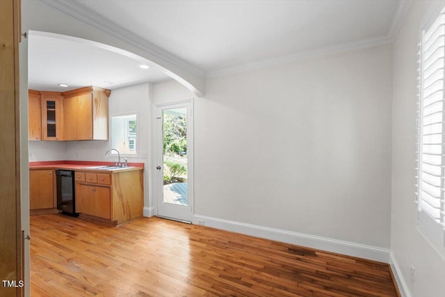 kitchen with a sink, light wood-style flooring, baseboards, dishwasher, and recessed lighting
