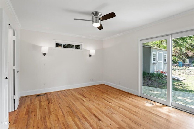 empty room featuring light wood-type flooring, ceiling fan, crown molding, and baseboards