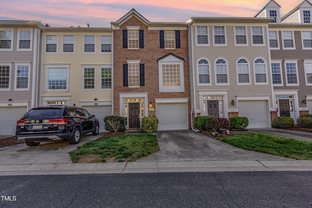 view of property featuring brick siding, a garage, and driveway