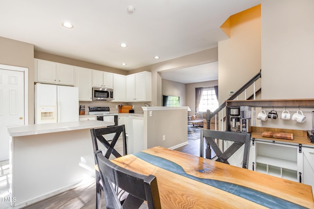 dining space featuring stairs, recessed lighting, and wood finished floors