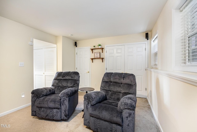 living area with baseboards and light carpet