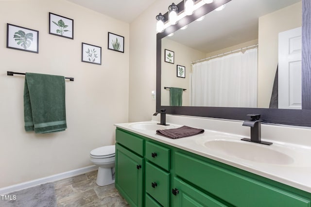 full bath featuring a sink, baseboards, toilet, and double vanity
