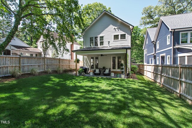 back of property featuring a lawn, a ceiling fan, a patio area, and a fenced backyard