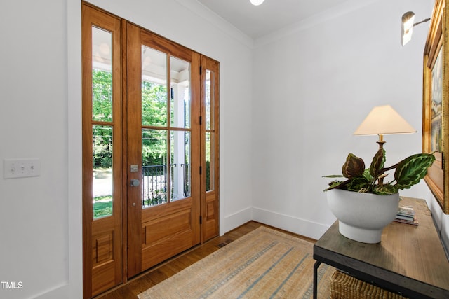 entrance foyer with crown molding, baseboards, and wood finished floors