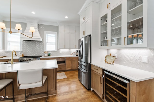 kitchen with custom exhaust hood, stainless steel appliances, beverage cooler, and backsplash