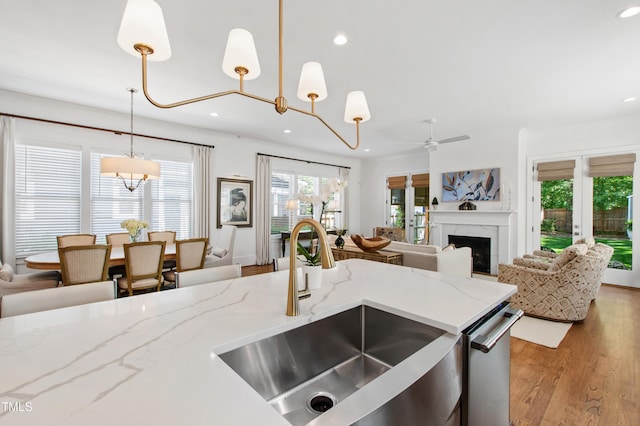kitchen with hanging light fixtures, a sink, ceiling fan with notable chandelier, recessed lighting, and open floor plan