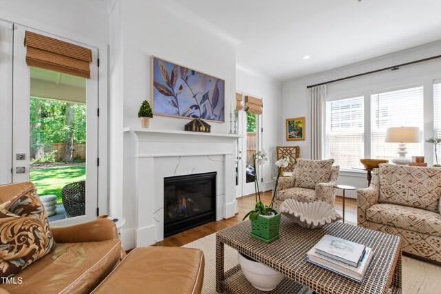 living room with recessed lighting, ornamental molding, wood finished floors, and a fireplace