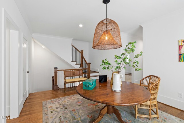 dining area with crown molding, wood finished floors, baseboards, stairway, and recessed lighting
