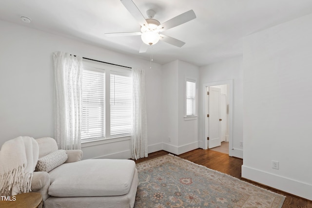 sitting room featuring baseboards, ceiling fan, and wood finished floors