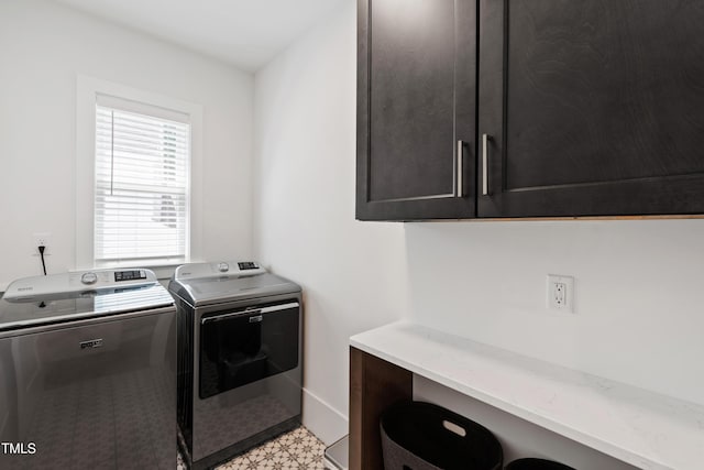 washroom featuring light floors, cabinet space, and washer and dryer