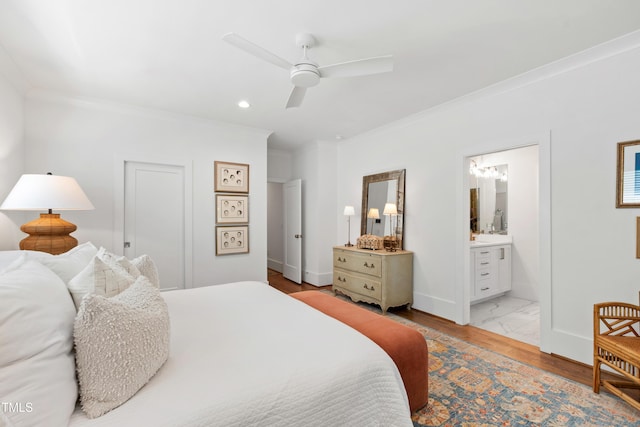 bedroom with crown molding, baseboards, recessed lighting, and connected bathroom
