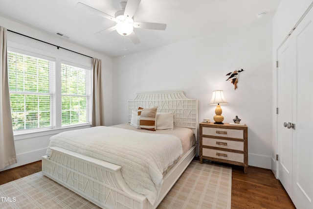 bedroom with baseboards, wood finished floors, and visible vents