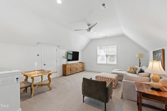 living area with a ceiling fan, visible vents, vaulted ceiling, baseboards, and light carpet