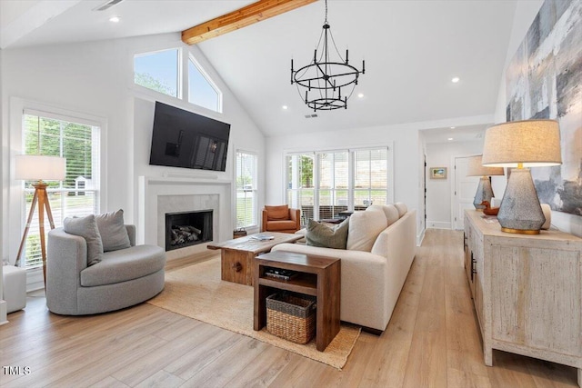 living room featuring a fireplace, high vaulted ceiling, beamed ceiling, and light wood finished floors