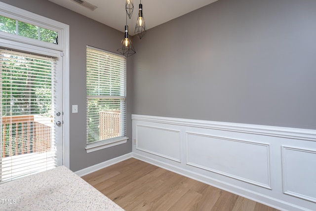 8719 Cypress Grove Run, Raleigh, NC 27612 - unfurnished dining area featuring visible vents, wainscoting, baseboards, light wood-style floors, and a decorative wall