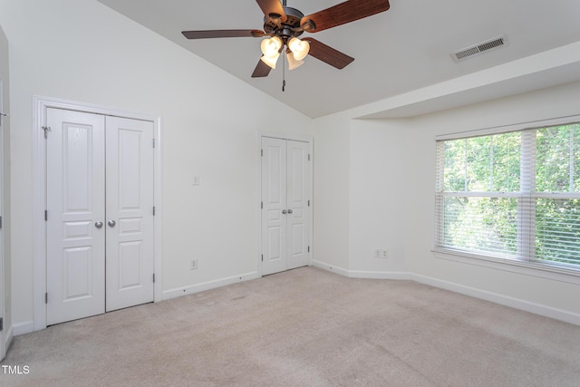 8719 Cypress Grove Run, Raleigh, NC 27612 - unfurnished bedroom featuring light colored carpet, two closets, baseboards, vaulted ceiling, and visible vents