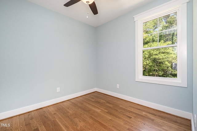 unfurnished room with baseboards, a ceiling fan, and wood finished floors