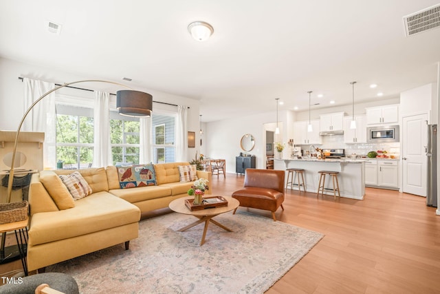 2404 Azalea Dr, Durham, NC 27703 - living area featuring light wood finished floors and recessed lighting