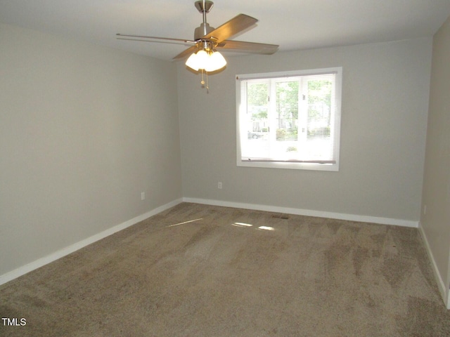 carpeted spare room with baseboards and ceiling fan