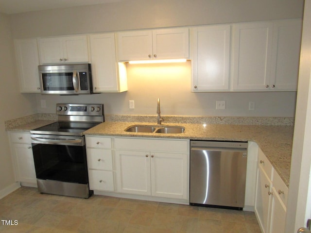 kitchen featuring a sink, white cabinetry, appliances with stainless steel finishes, and light stone countertops