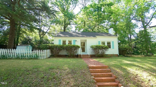 view of front of home featuring fence, a front yard, a chimney, crawl space, and entry steps