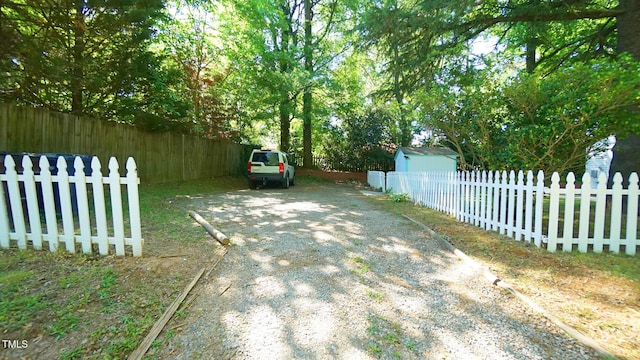 view of yard featuring fence and driveway
