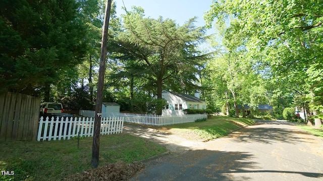 view of property exterior with a fenced front yard and driveway