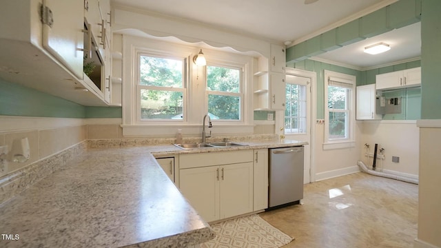 kitchen featuring stainless steel dishwasher, a healthy amount of sunlight, a sink, and light countertops