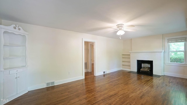 unfurnished living room with a fireplace, a ceiling fan, baseboards, visible vents, and dark wood-style floors