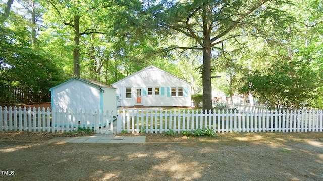 view of front of house with a storage unit, an outdoor structure, and a fenced front yard