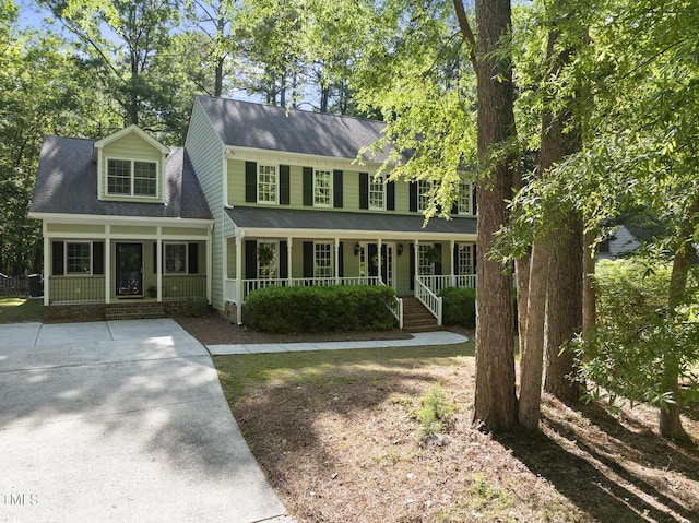 view of front facade with a shingled roof and a porch