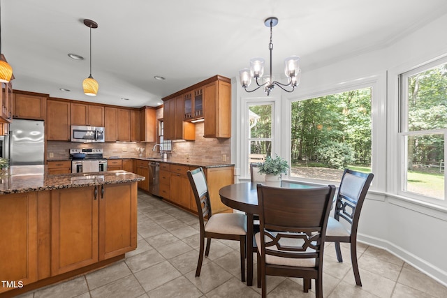 128 Cobblestone Dr, Chapel Hill, NC 27516 - kitchen featuring stainless steel appliances, healthy amount of natural light, brown cabinets, light tile patterned floors, and recessed lighting