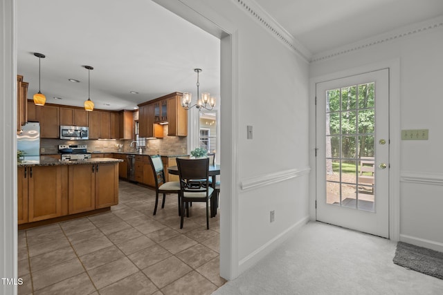 128 Cobblestone Dr, Chapel Hill, NC 27516 - kitchen with appliances with stainless steel finishes, a chandelier, backsplash, dark stone countertops, and brown cabinets