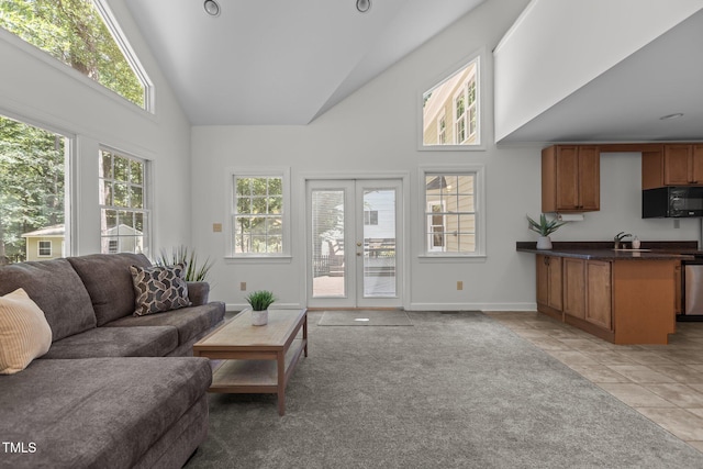 128 Cobblestone Dr, Chapel Hill, NC 27516 - living area with high vaulted ceiling, light tile patterned floors, french doors, baseboards, and light colored carpet