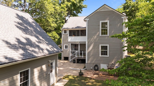 back of property featuring a patio and roof with shingles
