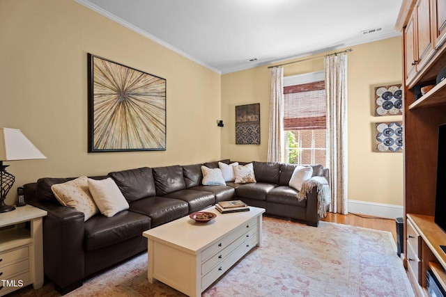living area with baseboards, ornamental molding, light wood-style flooring, and visible vents