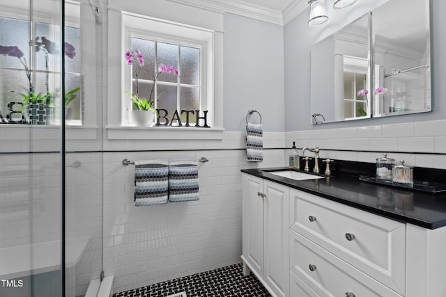 bathroom with crown molding, tile walls, a tile shower, and vanity