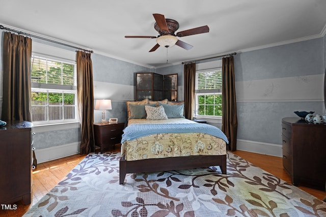 bedroom with crown molding, a ceiling fan, baseboards, and wood finished floors