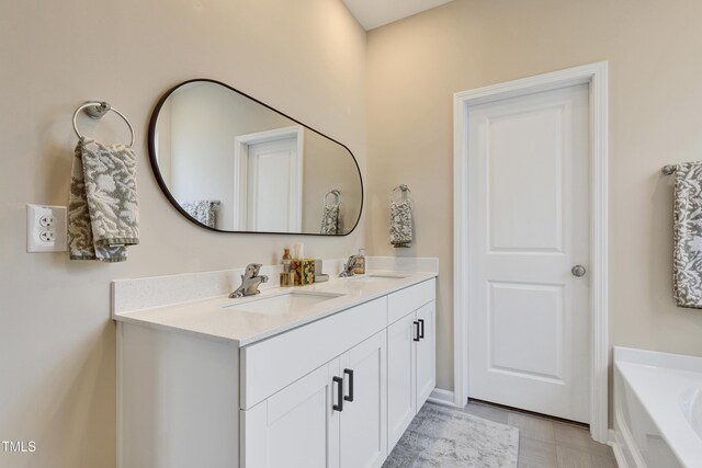bathroom featuring double vanity, a sink, and a bath