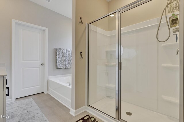 full bathroom featuring baseboards, a shower stall, and a bath