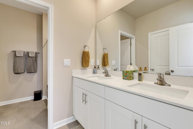 full bath with a sink, baseboards, and double vanity