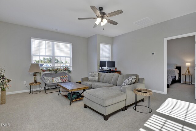 carpeted living area with visible vents, a ceiling fan, and baseboards