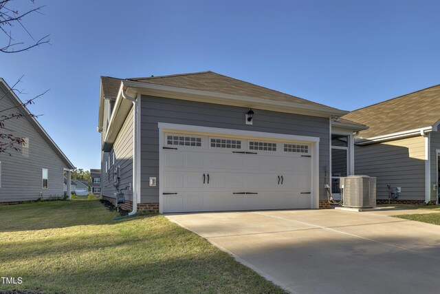exterior space with a garage, central AC, and a yard