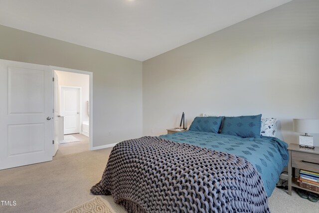 carpeted bedroom with baseboards and ensuite bathroom