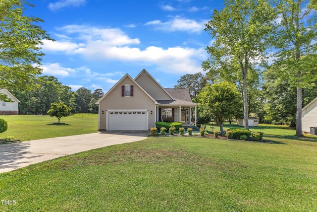 traditional-style house featuring a garage, a porch, driveway, and a front yard