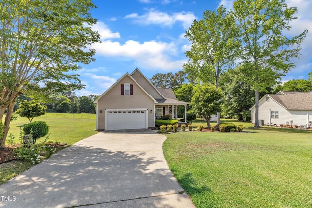 traditional home featuring concrete driveway, a garage, a porch, and a front lawn