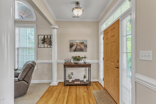 entryway with ornate columns, visible vents, plenty of natural light, and light wood-style floors