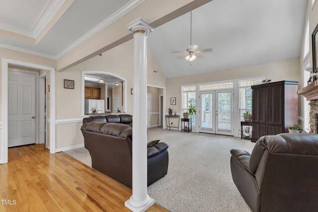 living area featuring ceiling fan, french doors, crown molding, arched walkways, and high vaulted ceiling