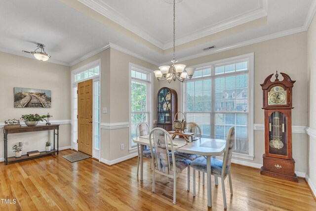 dining room featuring visible vents, crown molding, light wood-type flooring, baseboards, and a notable chandelier